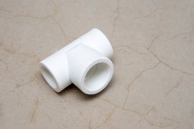 T şeklinde plastik, gri çimento arka planda tesisat, yakın plan, üst görüntü, kopyalama alanı