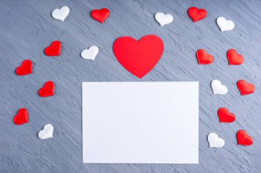 Aşk mektubu, sevgililer günü kartı. Beyaz ve kırmızı kalp şekilleri ile çevrili boş beyaz kağıt sayfa gri trend arka plan, kopyalama alanı, üst görünüm. Sevgililer Günü konsepti