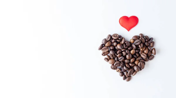 커피에 대한 사랑의 상징. 커피 원두로 만들어 진 심장 모양과 하얀 배경에 붉은 심장, — 스톡 사진