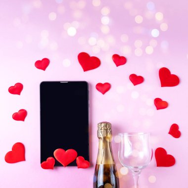 İnternetten Sevgililer Günü 'nü tebrik ederim. Şampanya şişesi, şarap kadehi, siyah tablet ya da telefon ekranı.