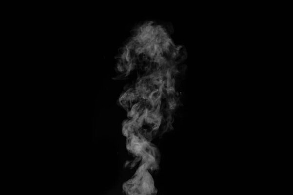 White vapour spray steam from air saturator. Smoke fragments on a black background. Abstract background, design element, for overlay on pictures