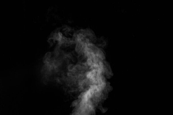 White vapour spray steam from air saturator. Smoke fragments on a black background. Abstract background, design element, for overlay on pictures