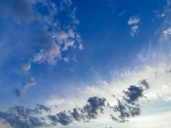 Cielo azul brillante con nubes blancas claras y emplumadas. Se puede utilizar como elemento de diseño, fondo natural — Foto de Stock
