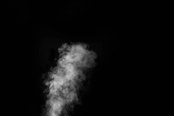 White vapour spray steam from air saturator. Smoke fragments on a black background