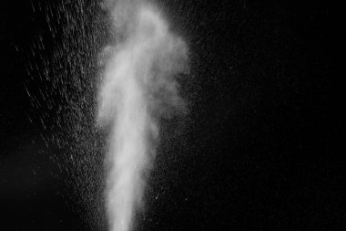 Beyaz kıvrımlı buhar yükseliyor ve siyah arka planda izole edilmiş farklı yönlere su sıçrıyor. Arkaplan, tasarım ögesi olarak kullanılabilir