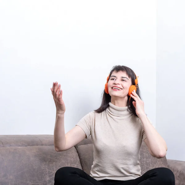 Retrato de una hermosa mujer sonriente escuchando música en el teléfono móvil, cantando una canción y un gesto, marco cuadrado — Foto de Stock