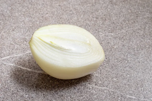 Metade fresca da cebola em um fundo de mesa cinza. Tempero natural para alimentos saudáveis — Fotografia de Stock