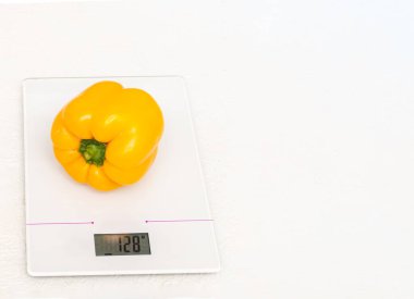 Diyet konsepti, düzgün beslenme, sağlıklı yeme. Mutfak pullarındaki taze sarı dolma biberler beyaz arkaplanda izole edilmiş, kopyalama alanı, yakın plan.