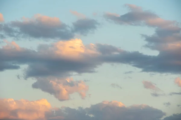 Una imagen colorida de un cielo dramático con increíbles nubes de rosa, púrpura, amarillo, blanco, oro contra el cielo oscuro de la noche después del atardecer. Fantástico verano, primavera, cielo invernal — Foto de Stock
