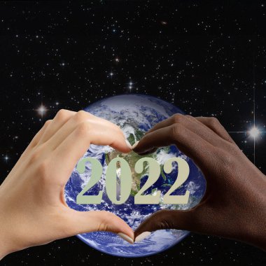 Dünya üzerinde kalp şeklinde siyah-beyaz eller ve 2022 rakamları.
