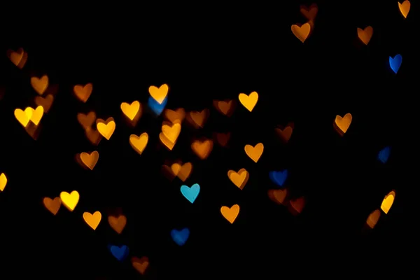 San Valentín grunge corazón en forma de luces de fondo. Oro amarillo y azul en forma de corazón sobre fondo negro Iluminación colorida bokeh para la decoración de San Valentín, fondo Love Pictures — Foto de Stock