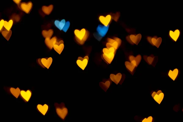 情人节心形背景灯.黄色的金色和蓝色的心形的黑色背景彩色灯罩装饰情人节，爱情图片背景 — 图库照片