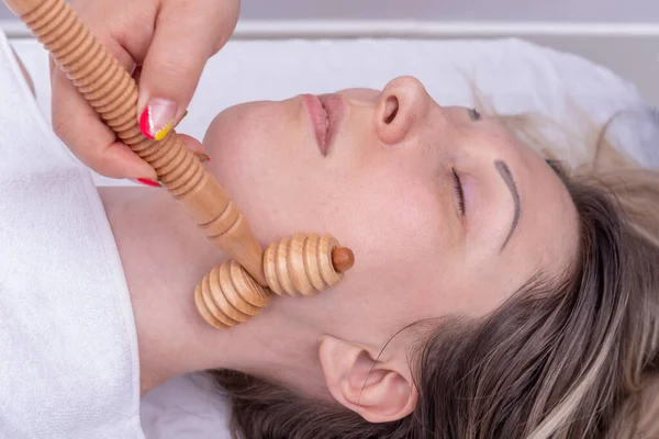 Madero terapia, anti-envejecimiento masaje relajante - Manos masajeando el cuello de las niñas con un masajeador de madera natural —  Fotos de Stock