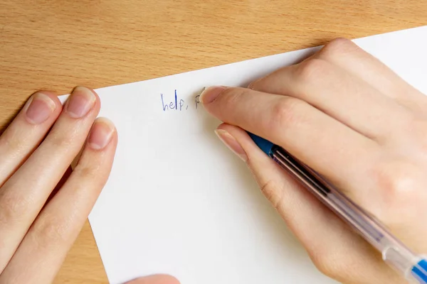 Το γυναικείο χέρι γράφει με στυλό σε λευκό φύλλο. Βοήθεια, κοντινό πλάνο. Έννοια της βίας — Φωτογραφία Αρχείου