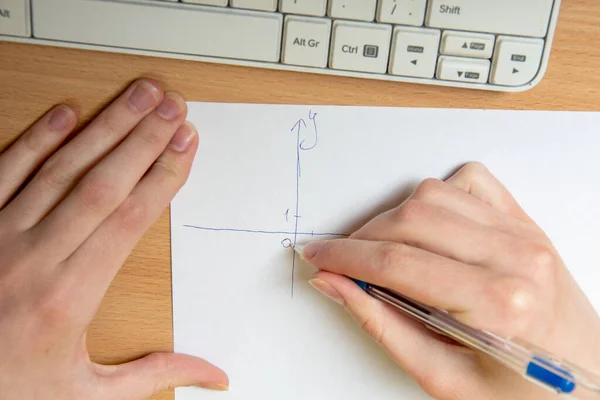 La mano femenina dibuja un eje para trazar, tarea de matemáticas, primer plano. Concepto de enseñanza en casa — Foto de Stock