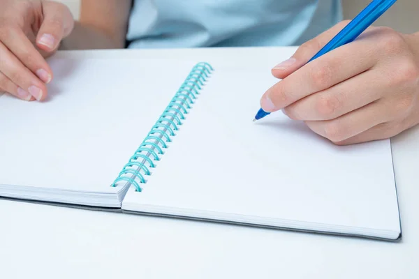 Mão de estudante feminina segurando uma caneta escrevendo em um caderno, grande poan, espaço de cópia. Uma mulher de negócios toma nota num caderno. De volta ao conceito de escola. Conceito de negócio — Fotografia de Stock