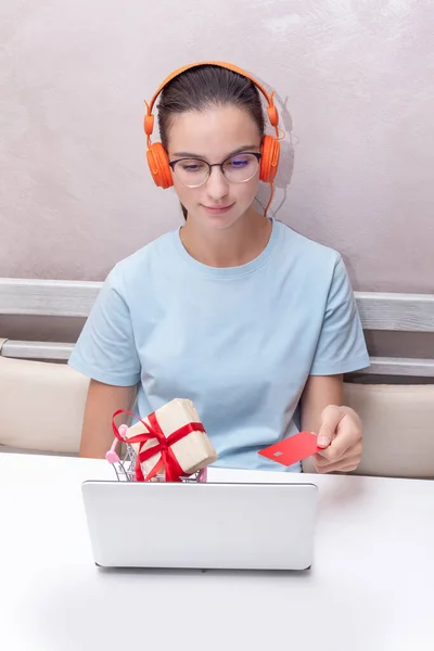Niña estudiante caucásica sentada en la mesa con tarjeta de crédito utilizando el ordenador portátil para comprar curso de aprendizaje en línea — Foto de Stock