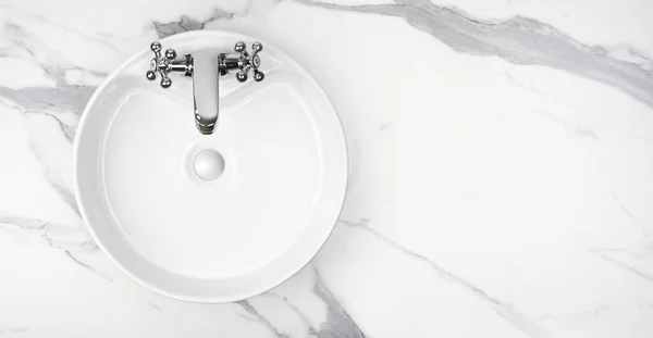 Round bathroom washing sink on marble stone surface, top view