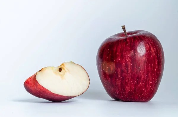 One apple and a half cut apple near each other, placed on a white table., Isolated apples. Whole red apple fruit with slice (cut) isolated on white background, Red apples isolated on white background.