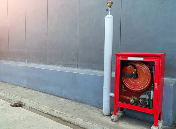 Yangın söndürücüler, arka plan için beton duvarın yanındaki kırmızı kutuda yangın söndürücüler, dış duvarlarda yangın söndürücüler..