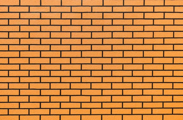 Modern style orange vintage brick wall texture for retro background. Orange brick wall surface spaced grooves grout black bricks for the background of the ad. Orange brick wall background.