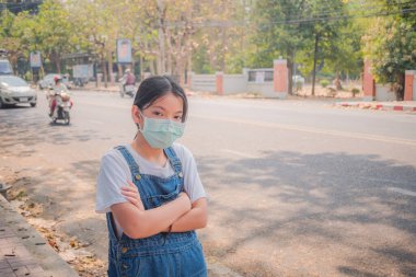 Coronavirus ve Hava kirliliği pm2.5 konsepti. 2019 Coronavirus hastalığının yayılması için maske takan genç bir kız. Yüzünde N95 maskesi olan genç kıza yaklaş..