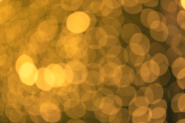 Soyut Altın Bokeh arkaplanı. Bokeh 'in odaklanmış altın ışıklarıyla soyut bir arka plan. Siyah arkaplandaki ışıklar bataklığı, Noel arkaplanı için soyut altın Bokeh halkaları.