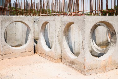 Kanalizasyon işinde kullanılmak üzere hazırlanmış beton bir rögar. Beton rögar kapağındaki büyük dairesel delikler su boruları içindir. Arka arkaya dizilmiş beton bir rögar. Büyük beton rögar kapakları.