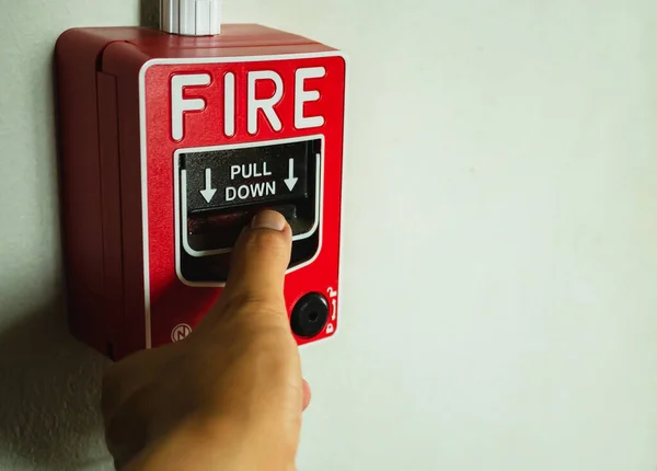 Binalarda ve ofislerde alarm düğmeleri var. Elin yangın alarmına basıyor. Acil bir durumda alarm düğmesine basıldığında.