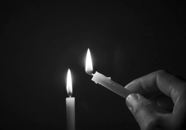 Siyah ve beyaz görüntü konsepti, karanlık bir odada mum ışığı, geceleri bir mum alevi.