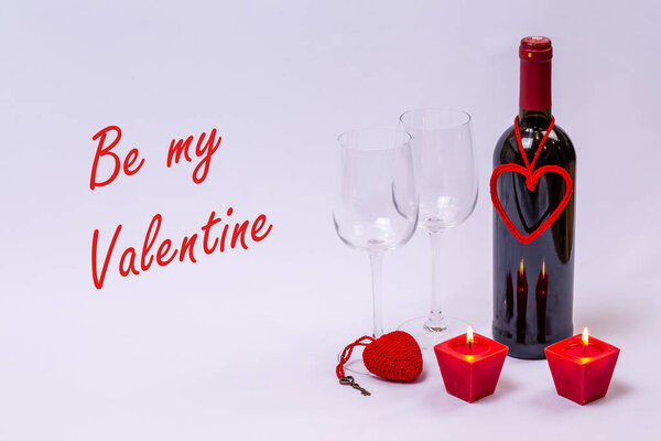 Красное вино и свечи на белом фоне.