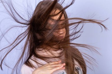 Uzun dalgalı saçlı bir kızın yakın portresi..