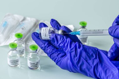 COVID-19 aşı geliştirme konsepti. Şırıngalı tıbbi eldivenler..
