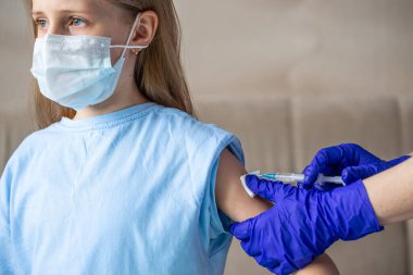 Kıza bir doktor tarafından koronavirüs aşısı yapıldı..