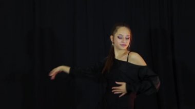 Bir dansçı kız evde antrenman yapıyor. Latin dansı pozları.