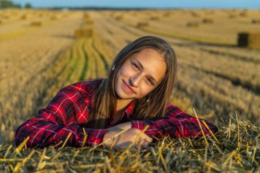 Kırmızı gömlekli kız samanlıkta oturuyor.. 