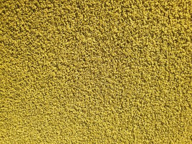 Sarı halı örtüsü. Polipropilen uzun halı dokusu arka planı. Üst görünüm