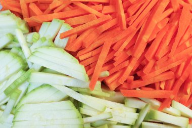 Çeşitli kesilmiş sebze havuçları ve kabak, sebze doğrama. Yakın çekim, doku