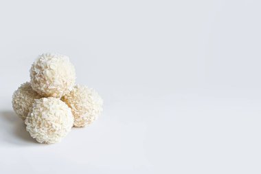 El yapımı şekerler. Tatlı toplar, beyaz çikolatalı şekerler ve beyaz izole edilmiş hindistan cevizi kırıntıları. Sağ tarafta uzayı kopyala. Seçici odak