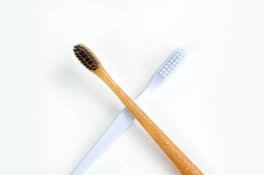 Bambu diş fırçası plastik diş fırçasına karşı konsepti. Diş fırçaları beyaz arka planda izole edilmiş. Dünyayı kurtar. Boşluğu kopyala