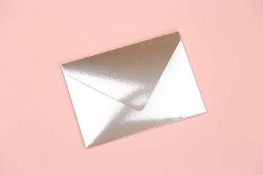 Pembe arka planda ayna kâğıdı festival zarfı, üst manzara. Davet için zarf veya nakit hediye.