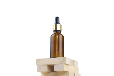 Cam kahverengi şişede serum ve tahta parçalarının üzerinde pipet. Cilt bakımı için temel yağ. Cilt bakımı, nemlendirici güzellik ürünü beyaz arka planda izole edilmiş. Yüz bakımı için kozmetoloji ürünü.