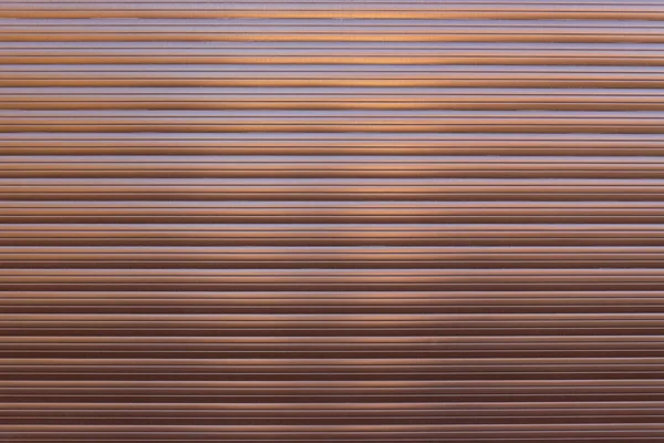 ブラウンローラーシャッタードアやカーテン 光沢のある茶色の金属折り畳み式のドアの背景と質感 — ストック写真
