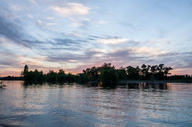 sakin nehir manzarası ve bulutlu arka planda ağaçlar, doğa konsepti