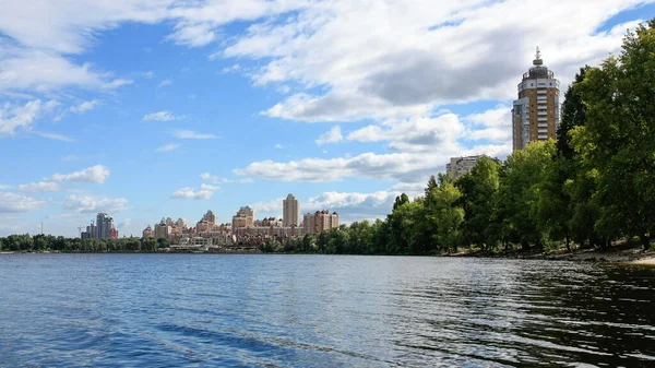 sakin nehir manzarası ve bulutlu gökyüzü arka planındaki ağaçların arkasındaki binalar, doğa kavramı, Kyiv, Ukrayna