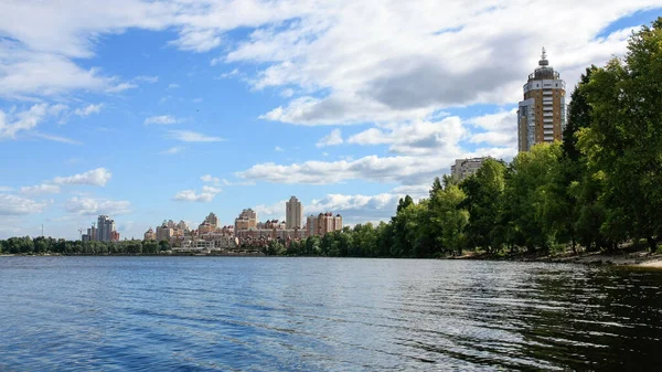 sakin nehir manzarası ve bulutlu gökyüzü arka planındaki ağaçların arkasındaki binalar, doğa kavramı, Kyiv, Ukrayna