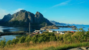 Norveç manzarası, küçük bir kıyı köyü ve görkemli fiyort dağları manzarası. 