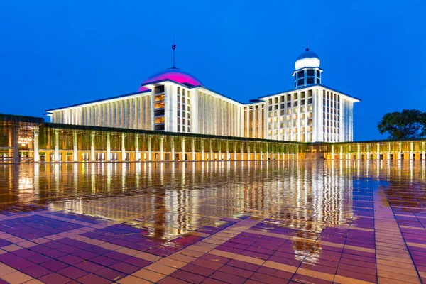 Jakarta, Endonezya - CIRCA Haziran 2021: Cakarta 'daki yeni İstiklal Camii' nin 2020 yılında yağışlı gün batımında su birikintisi ile yapılan yenilemeden sonra dışı