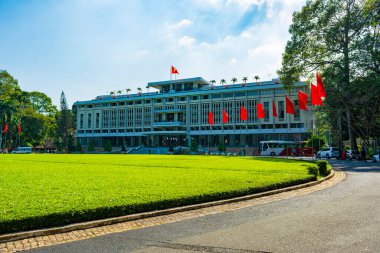 Ho Chi Minh Şehri, Vietnam - CIRCA Jan 2020: Bağımsızlık Sarayı cephesi, Ho Chi Minh Şehri, Vietnam; çimlerinin etrafında birkaç Vietnam bayrağı.