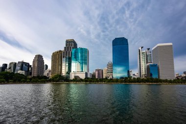 Benchakitti Parkı 'ndaki Ratchada Gölü' nün bulutlu öğleden sonrası manzarası. Benjakitti Parkı 'ndaki Bangkok şehir manzarası.